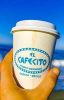 Puerto Escondido Oaxaca Mexico 2023 Coffee to go mug on the beach sand sea waves. photo