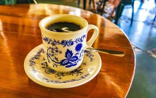 Blue white cup pot with black coffee wooden table Mexico. photo