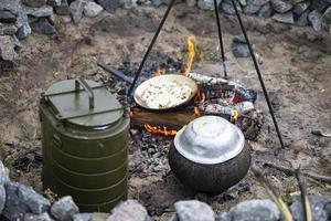 Cocinando en un fuego en caso de pérdida de alojamiento, guerras y natural desastres foto