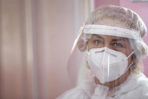 The face of a female doctor close-up in a protective suit. photo