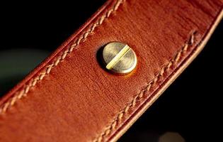 Part of a leather belt on a dark background. photo