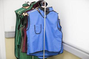 Rack of lead aprons used for x-ray protection in operating room, hospital photo