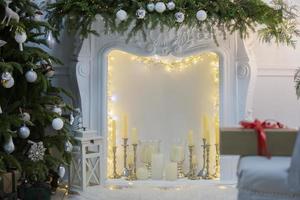 Beautiful Christmas interior of a room or photo studio with a Christmas tree and a fireplace.
