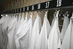 blanco médico vestidos colgar en perchas en el hospital. foto