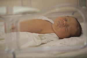 neonatología. un recién nacido en un especial incubadora para bebés en un hospital. foto