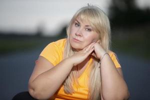 Portrait of a European middle-aged woman in a tracksuit, posing for the camera, relaxing. excited overweight woman in trendy tracksuit resting after exercising. photo