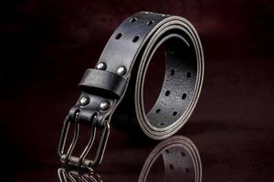 Black leather belt on a dark background. Leather products. photo