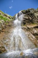 hermosa cascada en el montaña con azul cielo cascada en tropical tierras altas. foto