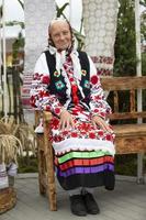 An old Belarusian or Ukrainian woman in an embroidered shirt. Slavic elderly woman in national ethnic clothes. photo