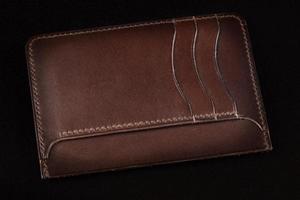 Brown leather wallet on a dark background. photo