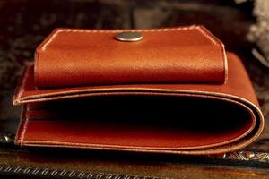 Part of a brown leather wallet or case with stitching. photo