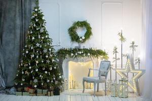 Beautiful Christmas interior of a room or photo studio with a Christmas tree and a fireplace.