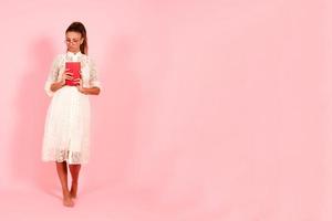 Pink background, girl reading books, book lover, student and many books, full growth photo