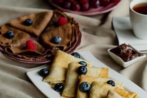 classic and chocolate pancakes with berries and fruits for breakfast, chocolate, tea, photo