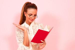 Pink background, girl reading books, book lover, student and many books, close-up photo