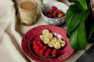 breakfast, cereal with milk, coffee with milk in a faceted glass, beterbrots with chocolate butter, berries and bananas photo