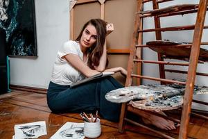 portrait of a beautiful young artist, draws pictures in the workshop photo