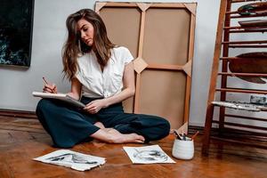 portrait of a beautiful young artist, draws pictures in the workshop photo