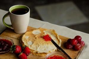 tortita con rojo caviar para desayuno, un taza de té foto