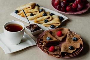 classic and chocolate pancakes with berries and fruits for breakfast, chocolate, tea, photo