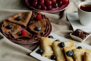 classic and chocolate pancakes with berries and fruits for breakfast, chocolate, tea, photo