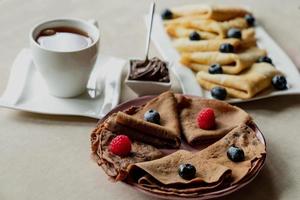 classic and chocolate pancakes with berries and fruits for breakfast, chocolate, tea, photo