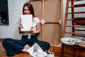 portrait of a beautiful young artist, draws pictures in the workshop photo