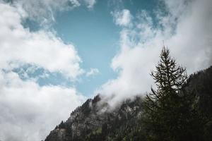 Majestic mountains in the Alps covered with trees and clouds photo