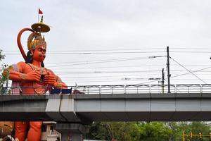 New Delhi, India - June 21, 2022 - Big statue of Lord Hanuman near the delhi metro bridge situated near Karol Bagh, Delhi, India, Lord Hanuman big statue touching sky photo