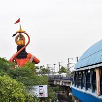 New Delhi, India - June 21, 2022 - Big statue of Lord Hanuman near the delhi metro bridge situated near Karol Bagh, Delhi, India, Lord Hanuman big statue touching sky photo