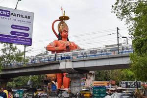 New Delhi, India - June 21, 2022 - Big statue of Lord Hanuman near the delhi metro bridge situated near Karol Bagh, Delhi, India, Lord Hanuman big statue touching sky photo