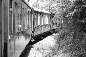 Toy Train moving on mountain slope, beautiful view, 1 side mountain, 1 side valley moving on railway to the hill, among green natural forest. Toy train from Kalka to Shimla in India-Black and White photo