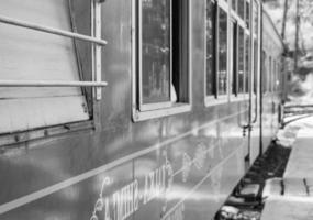 Toy Train moving on mountain slope, beautiful view, 1 side mountain, 1 side valley moving on railway to the hill, among green natural forest. Toy train from Kalka to Shimla in India-Black and White photo