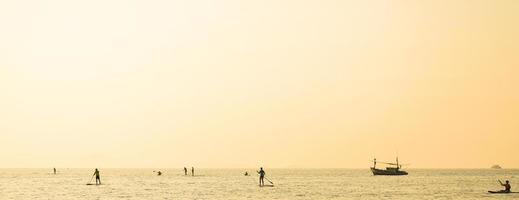 Inspiration silhouette of stand up paddle board player in the sunset. concept of happy vacation and friendly family. photo