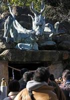 continuar estatua a continuar palacio, parte de enoshima santuario en enoshima península con anónimo personas visto desde el espalda en un soleado día foto