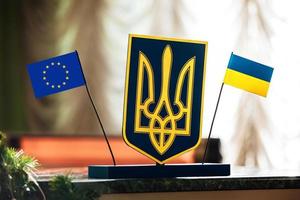 meeting Ukraine and European Union. Emblem of Ukraine flag of blue and yellow colours, trident and flag of UE blue with stars. concept of political tension, war, crisis, strategy and sanctions photo