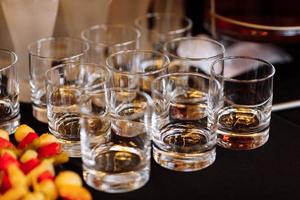 glasses with cognac, whiskey stand on the bar. a lot of glasses with cognac. alcohol in the glasses. Various alcohol drinks standing on bar. glasses with cognac on the bar photo