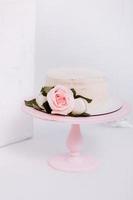 hermoso pastel de crema blanca decorado con velas de 2 años y rosas en estudio blanco. fiesta de cumpleaños - concepto de un año de nacimiento, fiesta, celebración de la vida y momentos memorables. foto