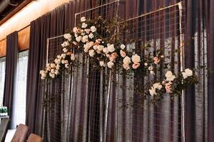 Wedding decor. Photographic area is a stylish wedding decoration. Decorated with flowers, mini florals. Wedding photo zone with flowers. Hand made wedding decorations. Place for taking pictures