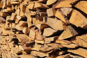 texture of pine firewood. Chipped firewood is on the heap. Woodpile of firewood close-up. A stack of dry firewood, visible texture and cracks in the tree. selective focus. photo