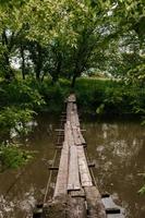 Old wooden bridge, wooden bridge across a small river, bridge with nature. photo