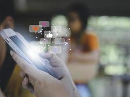 Concept with notification icons of like being happyand social media interactions on mobile phone,message, email, comment ,businessman hands holding device photo