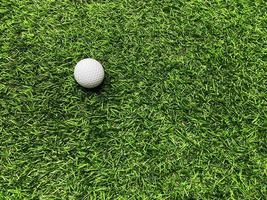 Golf ball close up on green grass on blurred beautiful landscape of golf  background.Concept international sport that rely on precision skills for health relaxation. photo