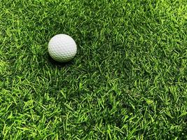 Golf ball close up on green grass on blurred beautiful landscape of golf  background.Concept international sport that rely on precision skills for health relaxation. photo