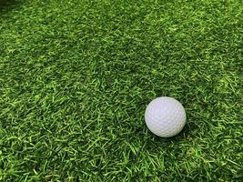 Golf ball close up on green grass on blurred beautiful landscape of golf  background.Concept international sport that rely on precision skills for health relaxation. photo