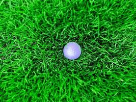 Golf ball close up on green grass on blurred beautiful landscape of golf course with sunrise,sunset time on background.Concept international sport that rely on precision skills for health relaxation. photo