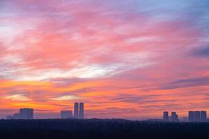 colorful cloudscape over city park and towers photo