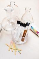test tubes with liquids, flask and indicator paper photo