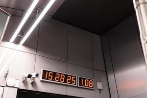 display of digital clock and video cameras on wall photo