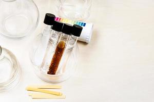 test tubes, flasks and litmus papers on table photo
